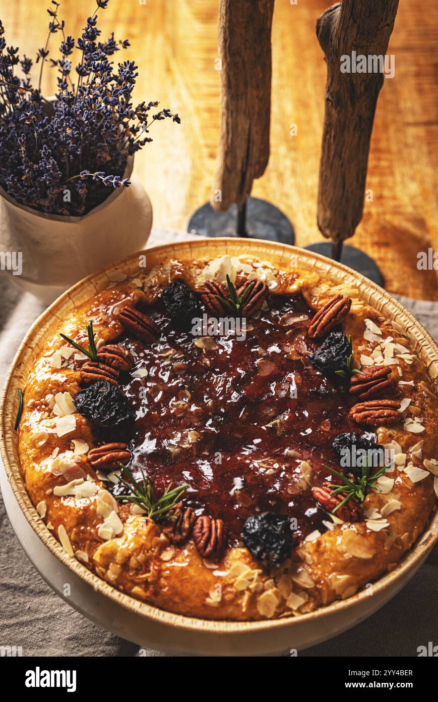 Köstliche Feigen- und Rosmarintorte mit Pekannüssen und Mandelflocken in einer Holzschale Stockfoto