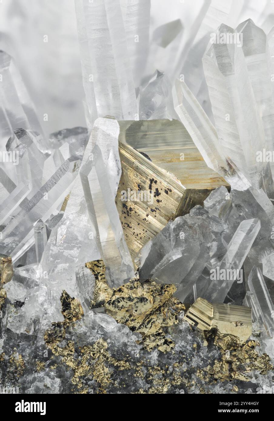 Nahaufnahme von hoch aufragenden klaren Quarzkristallen, gemischt mit auffälligem goldenem Pyrit aus mineralreichen Regionen Perus. Stockfoto