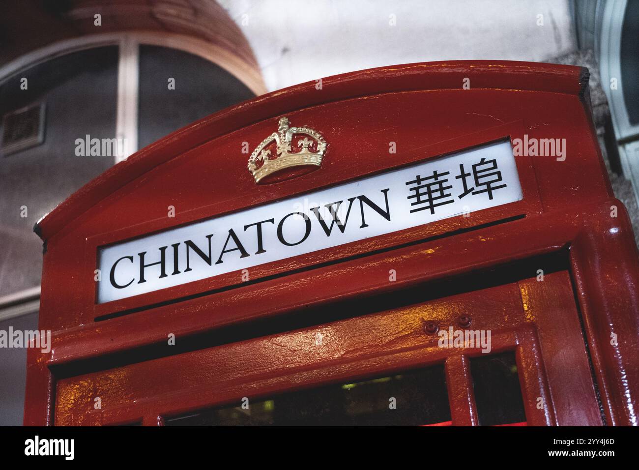 Eine traditionelle rote Telefonkabine mit Chinatown-Schild mit chinesischen Schriftzeichen und einem Kronemblem. Die Vintage-Struktur ist ikonisch für den urbanen Bri Stockfoto