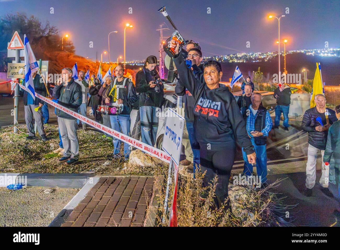 Kishon, Israel - 17. Dezember 2024: Menschen protestieren in der Nähe des Kishon Internierungszentrums, um Aktivisten zu unterstützen, die verhaftet wurden, nachdem sie Marineflampen abgefeuert hatten. Stockfoto