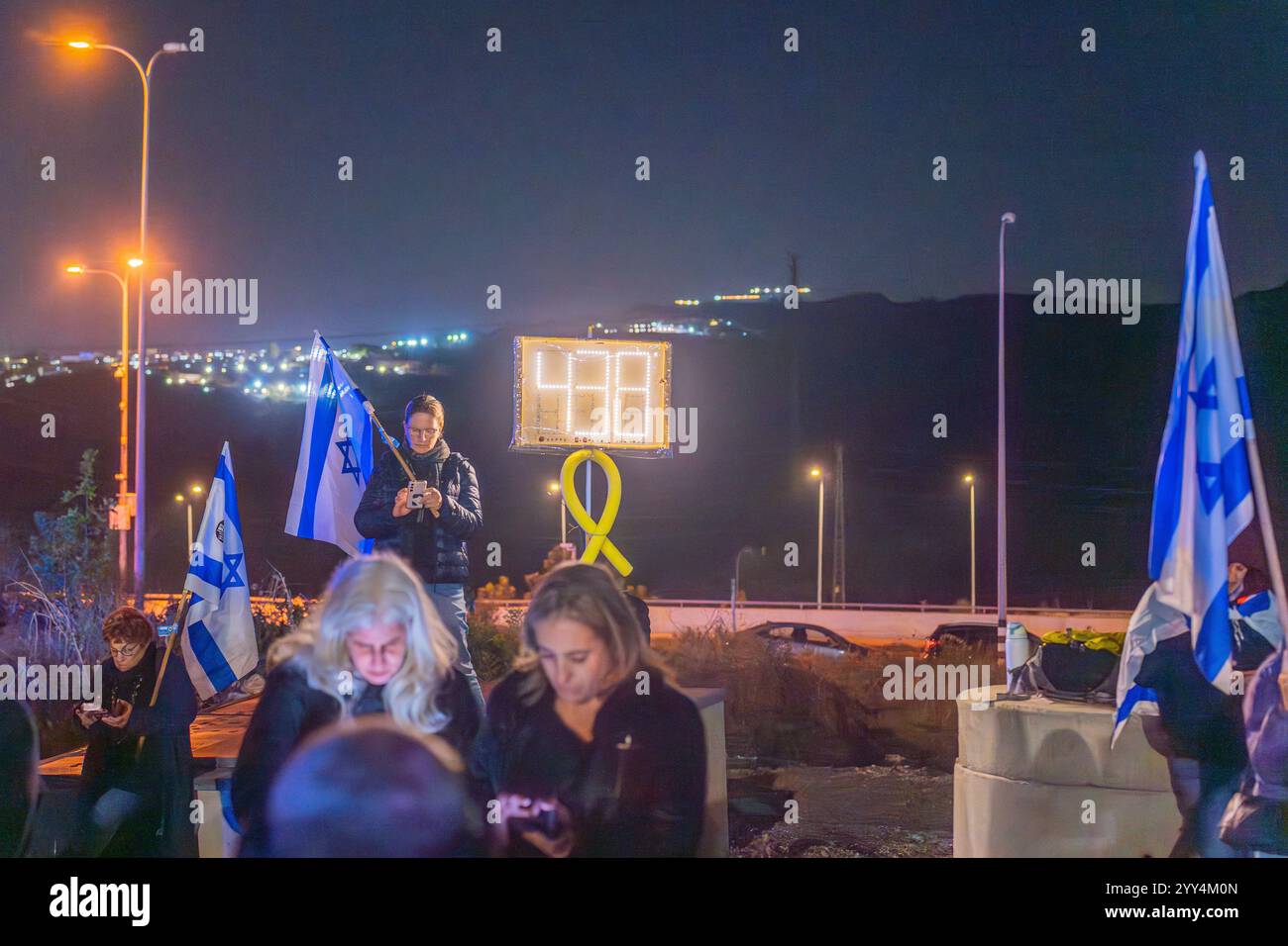 Kishon, Israel - 17. Dezember 2024: Menschen protestieren in der Nähe des Kishon Internierungszentrums, um Aktivisten zu unterstützen, die verhaftet wurden, nachdem sie Marineflampen abgefeuert hatten. Stockfoto