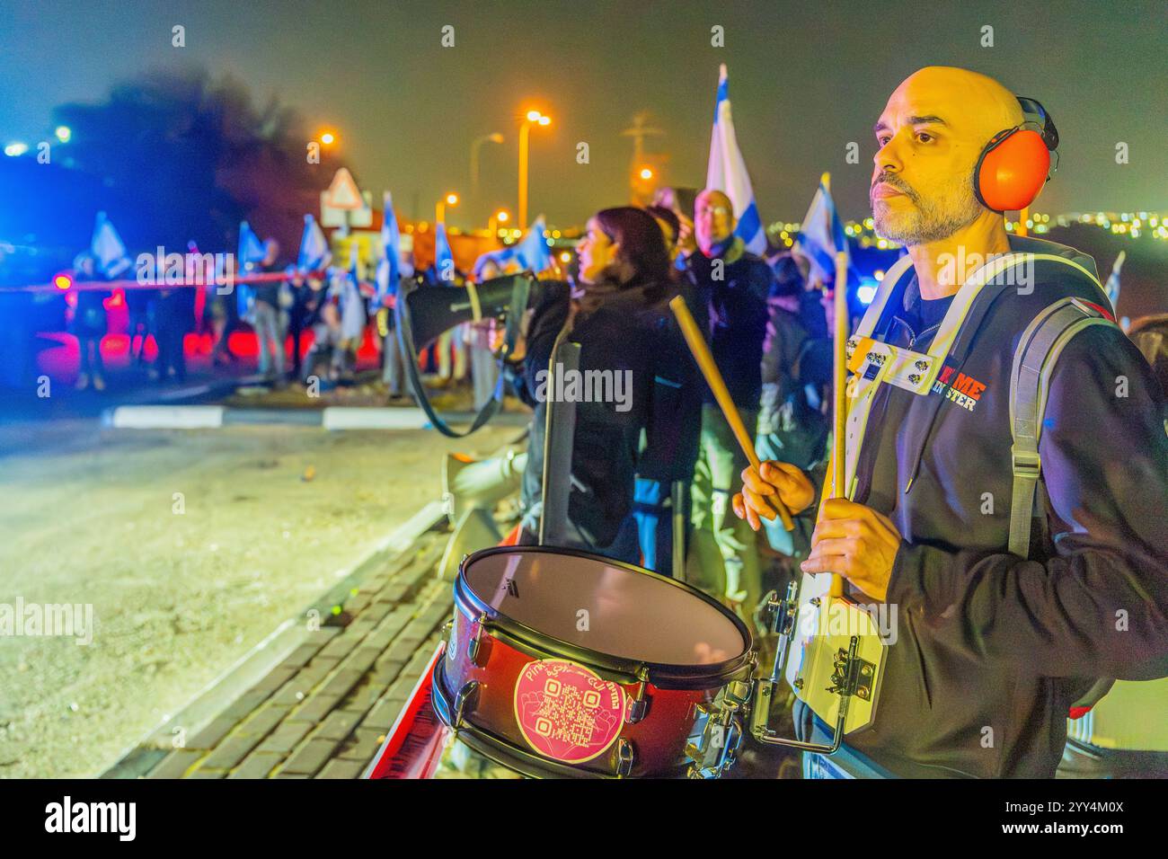 Kishon, Israel - 17. Dezember 2024: Menschen protestieren in der Nähe des Kishon Internierungszentrums, um Aktivisten zu unterstützen, die verhaftet wurden, nachdem sie Marineflampen abgefeuert hatten. Stockfoto