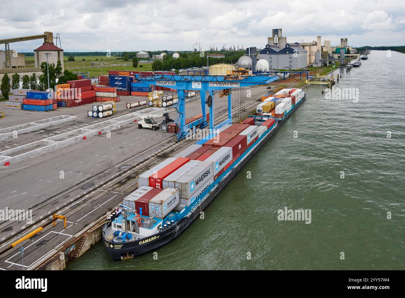 Containerbeladung im Hafen von Mulhouse Ottmarsheim am Canal Grande des Elsass, parallel zum Rhein. Containerschiff im industriellen Flusshafen Stockfoto