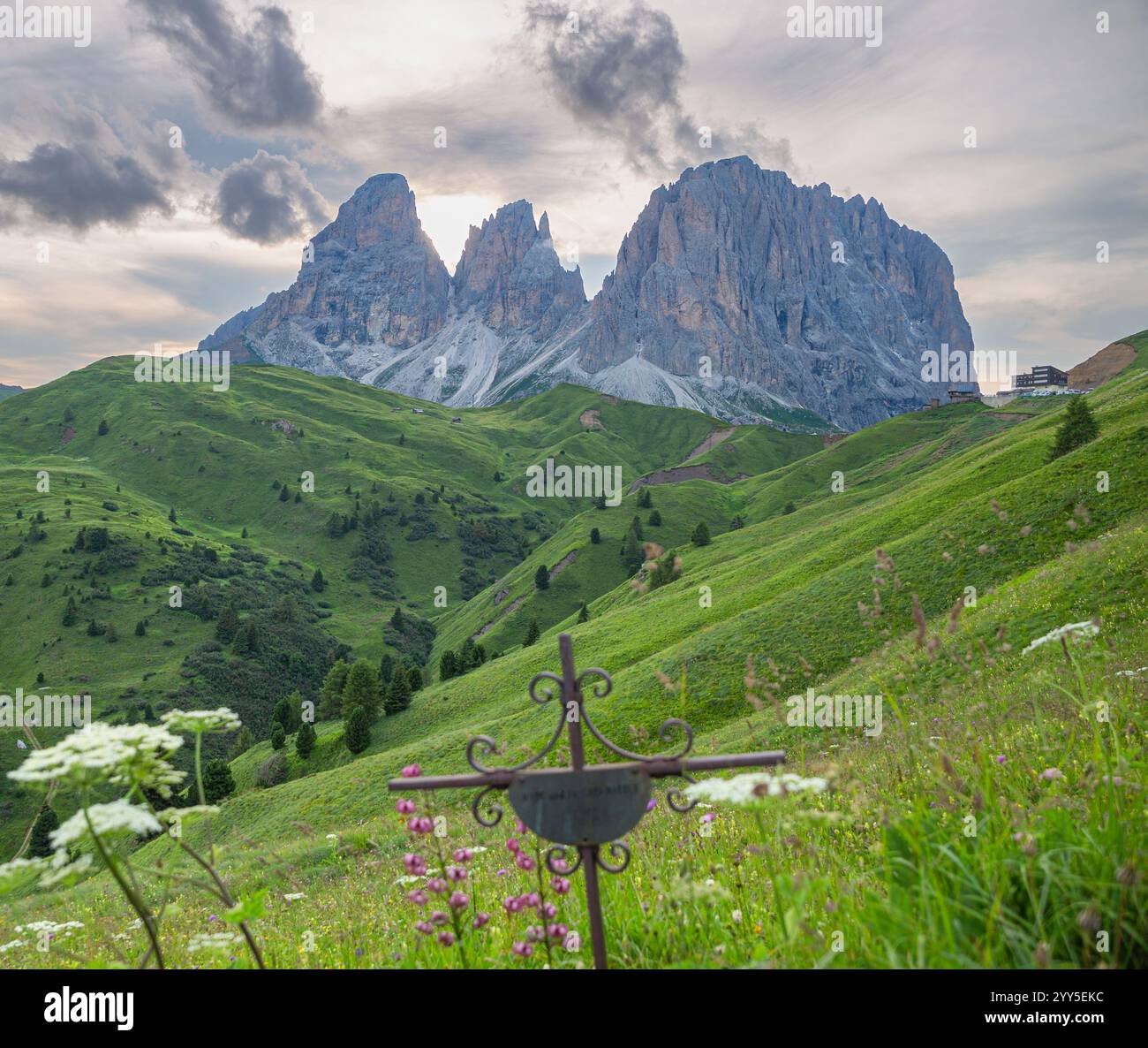 Ein Kreuz auf einem Hügel mit einem felsigen Berg im Hintergrund, erinnere dich an jemanden, der dort gestorben ist, Dolomiten, Italien Stockfoto