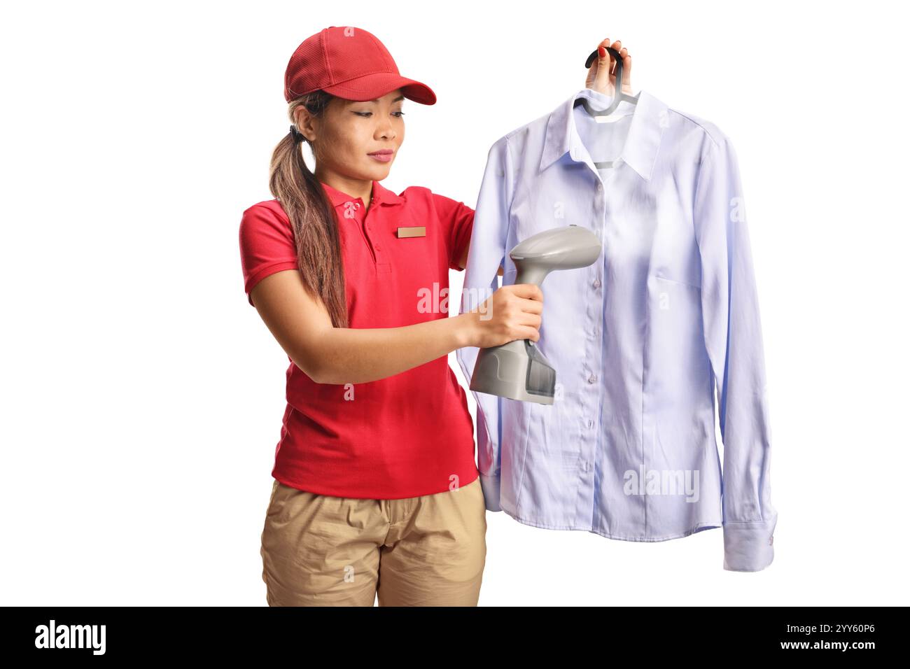 Weibliche Reinigungsarbeiterin, die ein Hemd mit einem Handdampfbügeleisen auf weißem Hintergrund bügelt Stockfoto