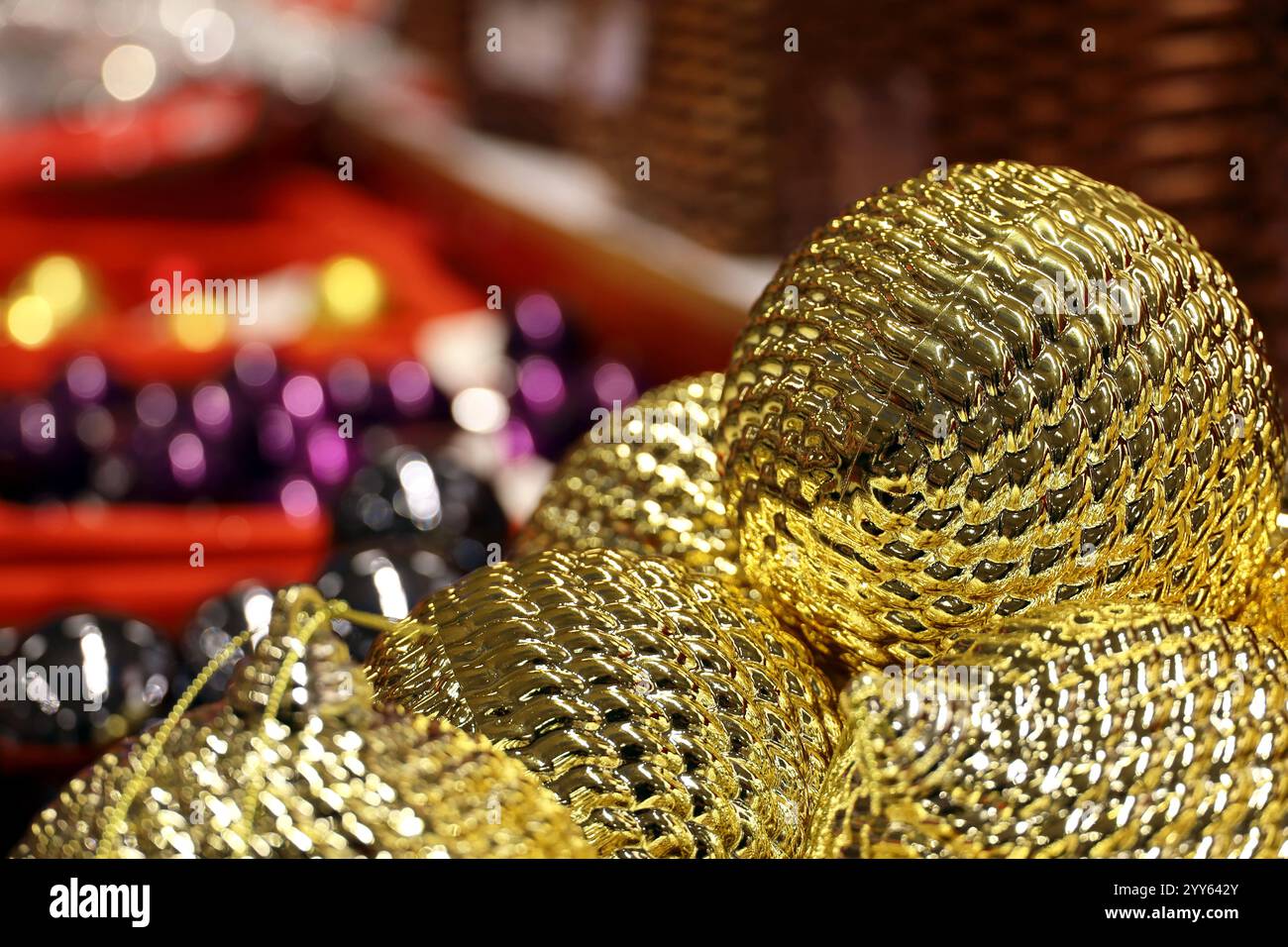 Weihnachtsspielzeug, goldene Kugeln im Korb auf festlichem Hintergrund. Neujahrsdekoration in einem Laden Stockfoto