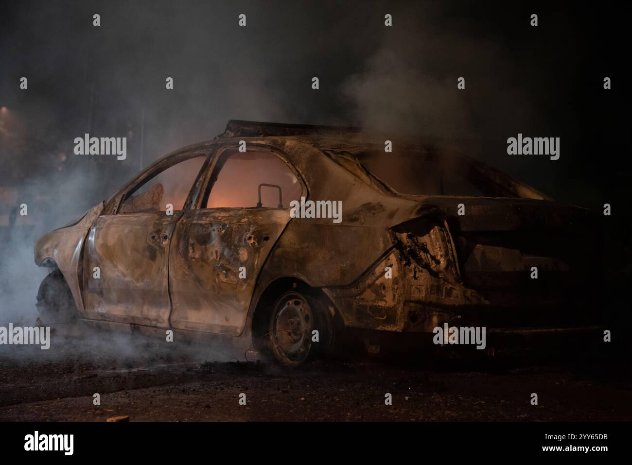 Brennende Polizeiwagen im Zentrum der Stadt in der Nähe der Kirche während der Unruhen, die durch Demonstrationen und Gewalt gegen das Regime verursacht wurden. Stockfoto