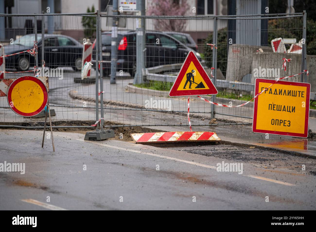 Die innerstädtische Straße ist durch Schilder und die Grenze um die Straßenarbeiten geschlossen. Bau- und Straßenschild in der Innenstadt. Achtung-Symbol, Arbeiten werden ausgeführt. Stockfoto