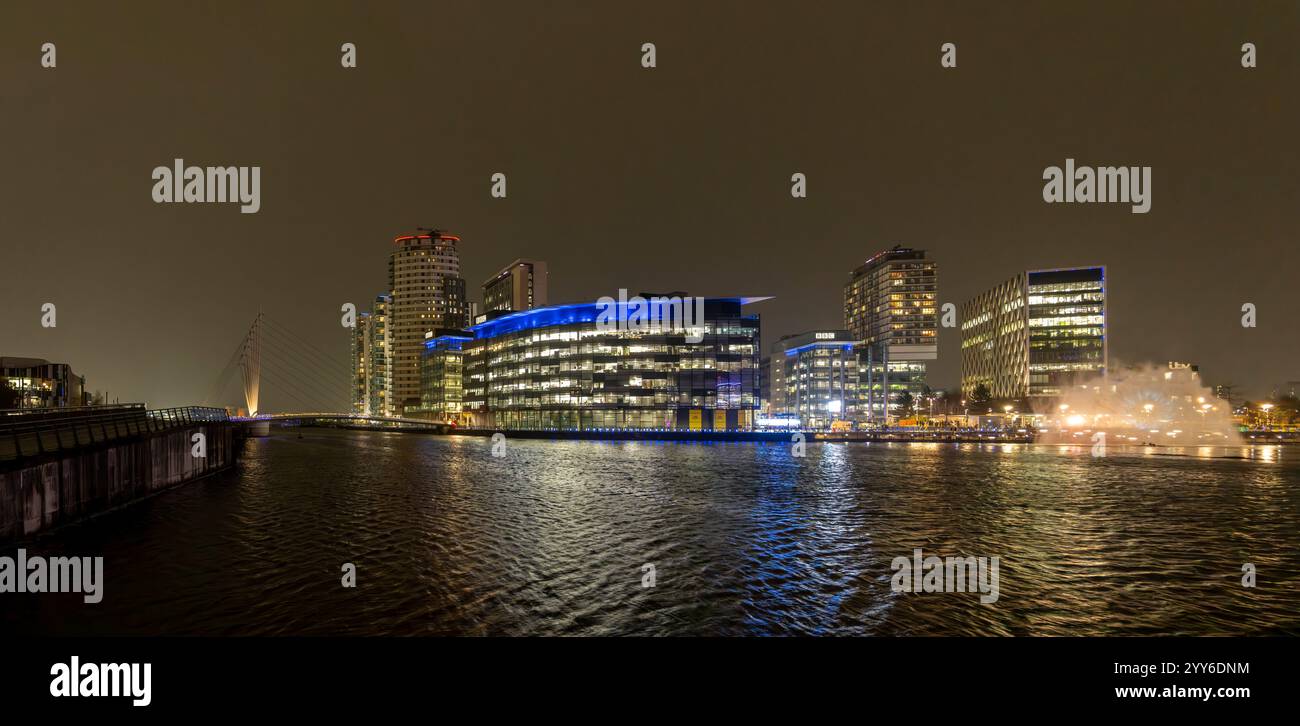 Helle Lichter der modernen Architektur beleuchten die Salford Waterfront in Media City und zeigen eine lebhafte Stadtlandschaft bei Nacht. Stockfoto