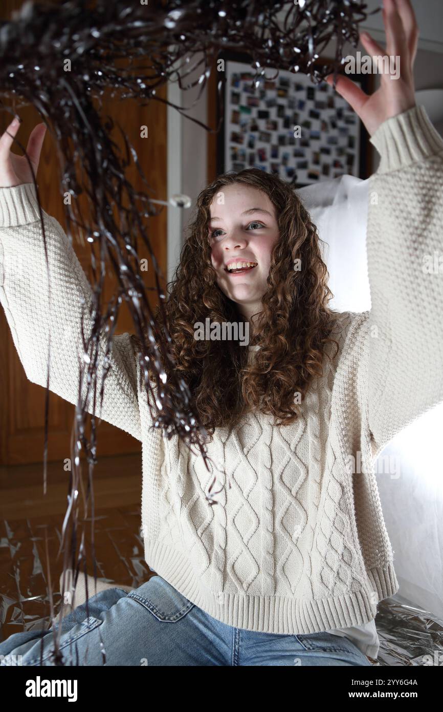 Teenager-Mädchen, das verdrehte, aufgewickelte Kassettenband in die Luft wirft - Konzeptdatenspeicher Musik verwirrt Stockfoto