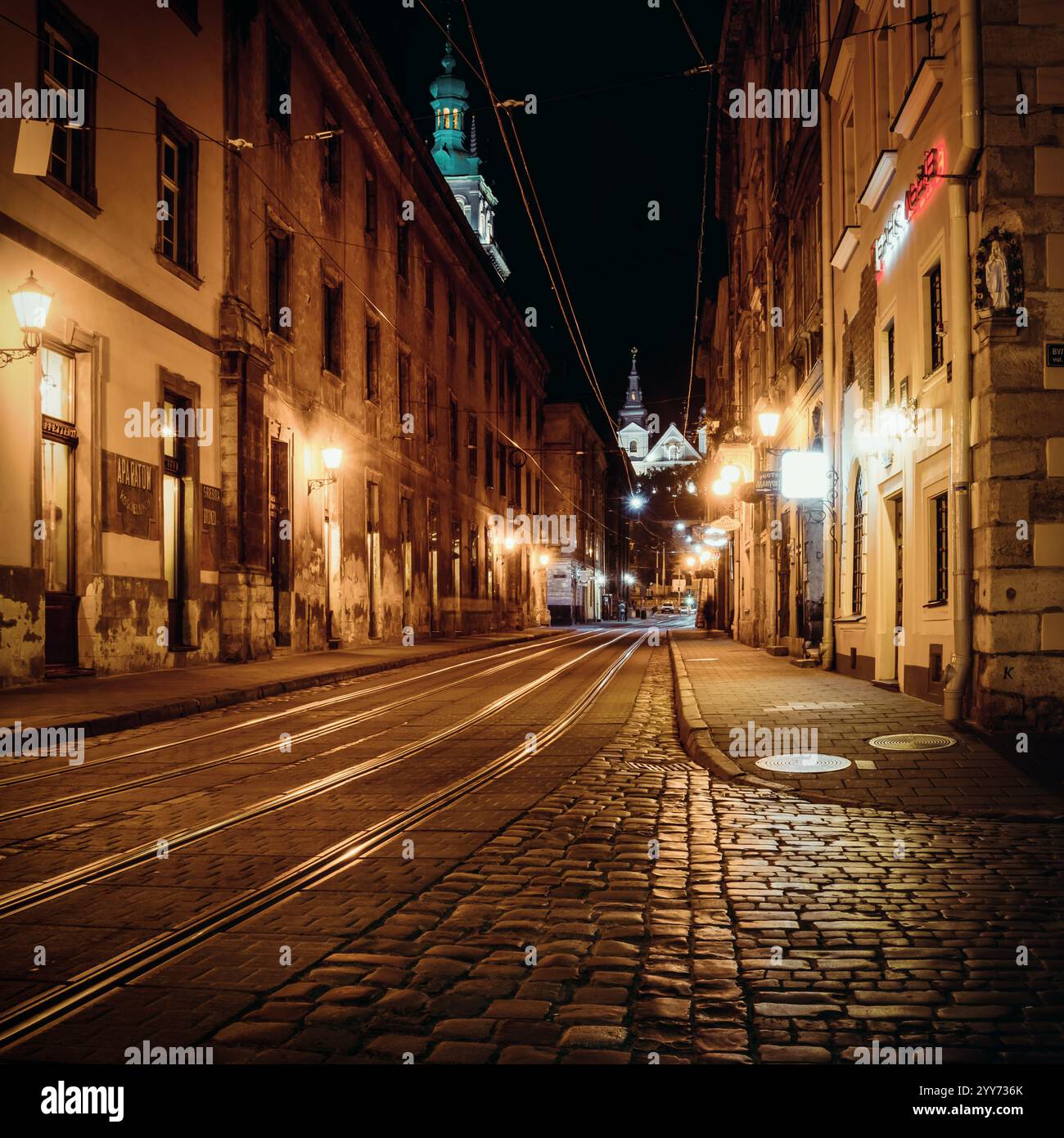 Lviv Altstadt bei Nacht. Leere Straße mit Straßenbahnschienen im Stadtzentrum. Stockfoto