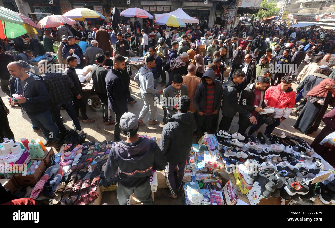 Gaza. Dezember 2024. Menschen werden am 19. Dezember 2024 auf dem Hauptmarkt von Deir al-Balah, dem zentralen Gazastreifen, gesehen, wo es an Bargeld mangelt und Menschen aufgrund hoher Preise nicht in der Lage sind, Grundnahrungsmittel zu kaufen. Quelle: Rizek Abdeljawad/Xinhua/Alamy Live News Stockfoto