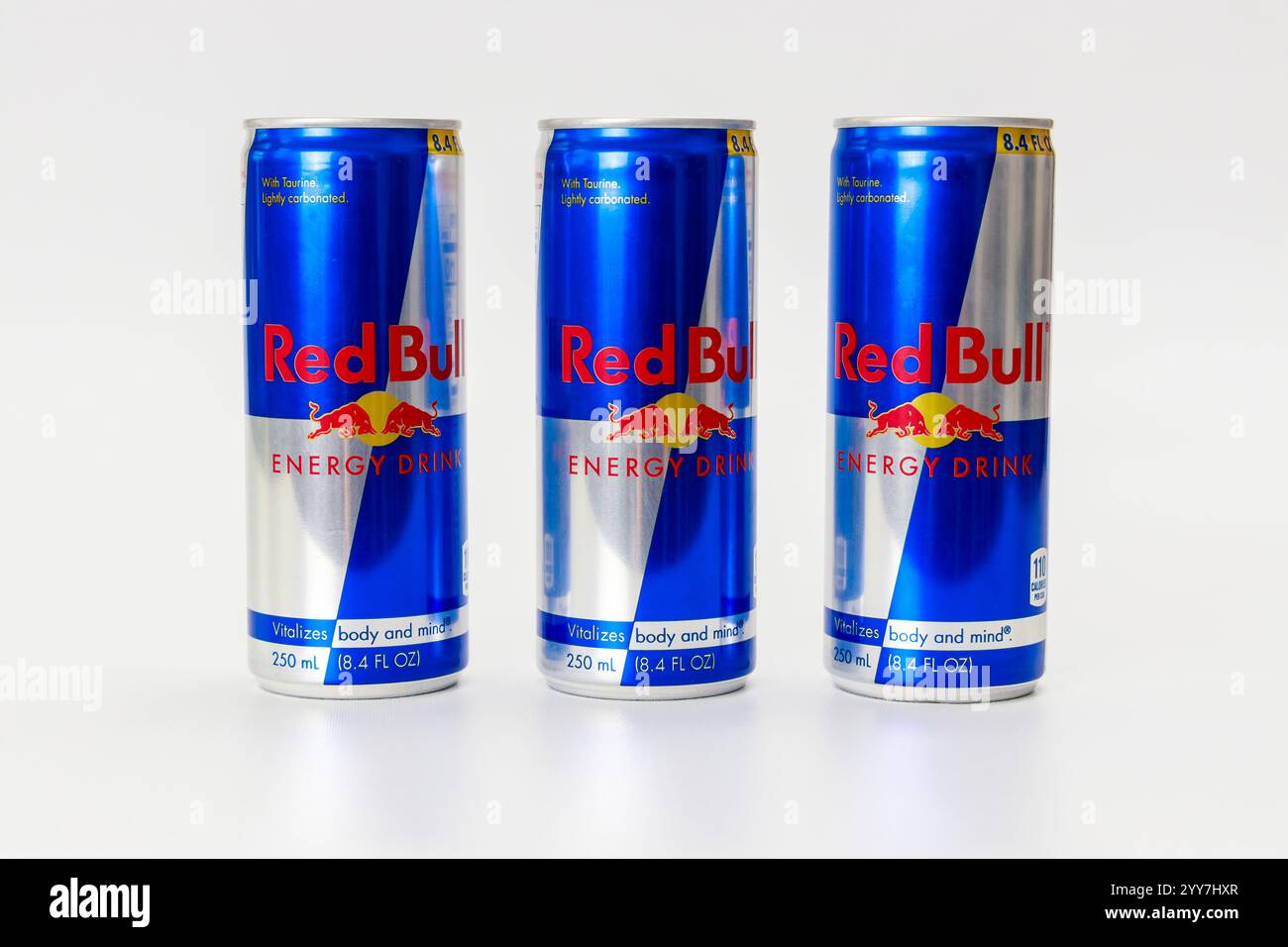 Drei Dosen Energydrink auf schlichtem Hintergrund mit lebendigem Design und Branding Stockfoto