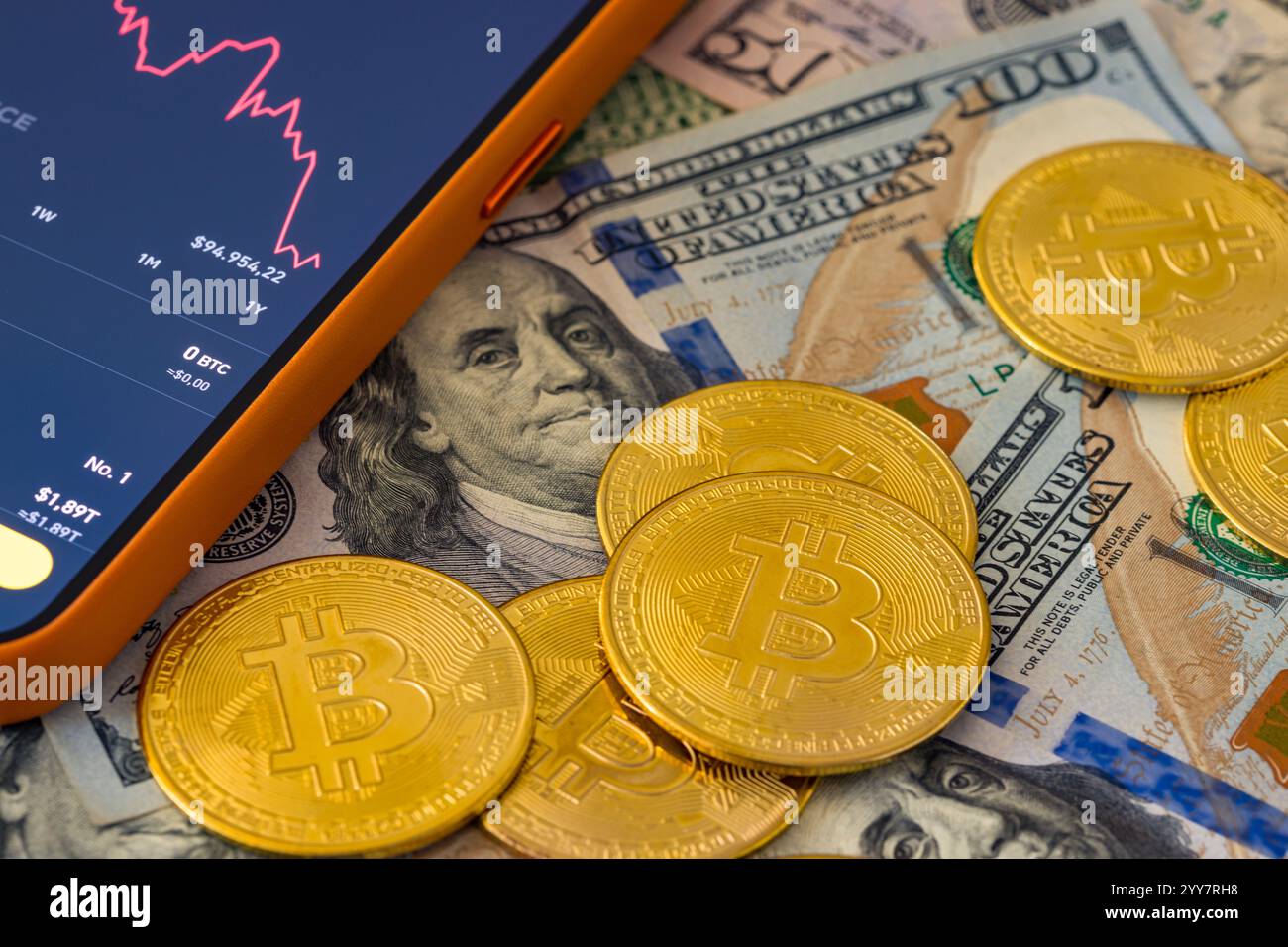 Ansicht von oben auf Bitcoin-Münzen, die auf hundert Dollar-Scheinen liegen Stockfoto