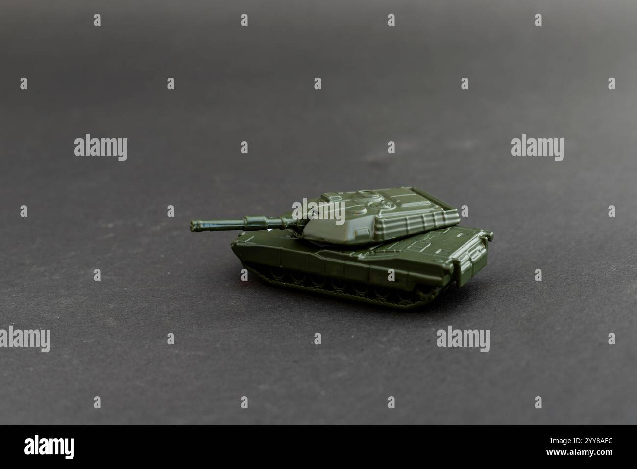 Kleiner, grüner Miniaturpanzer auf dunklem Hintergrund Stockfoto