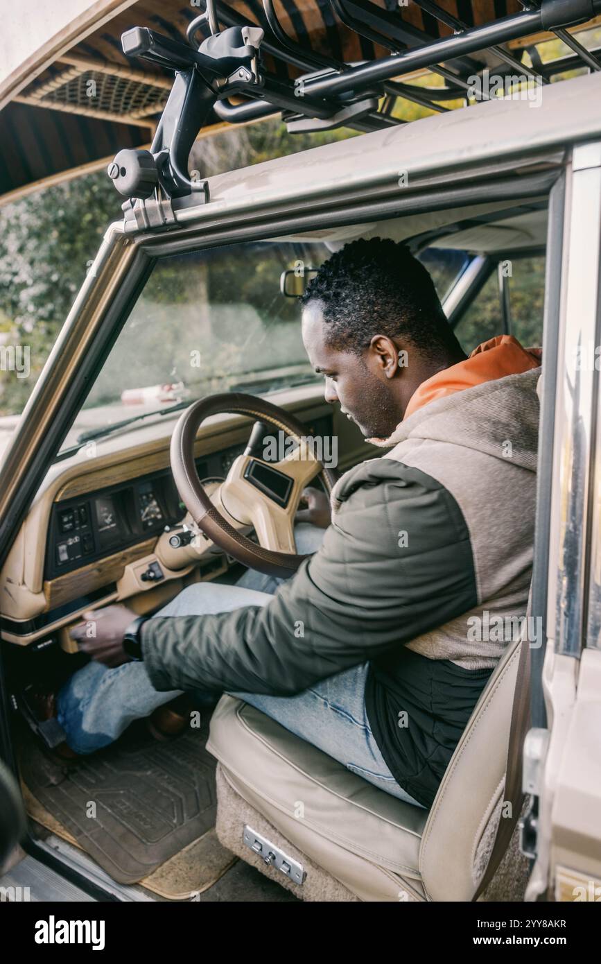 Der Mann greift nach etwas im Oldtimer Stockfoto