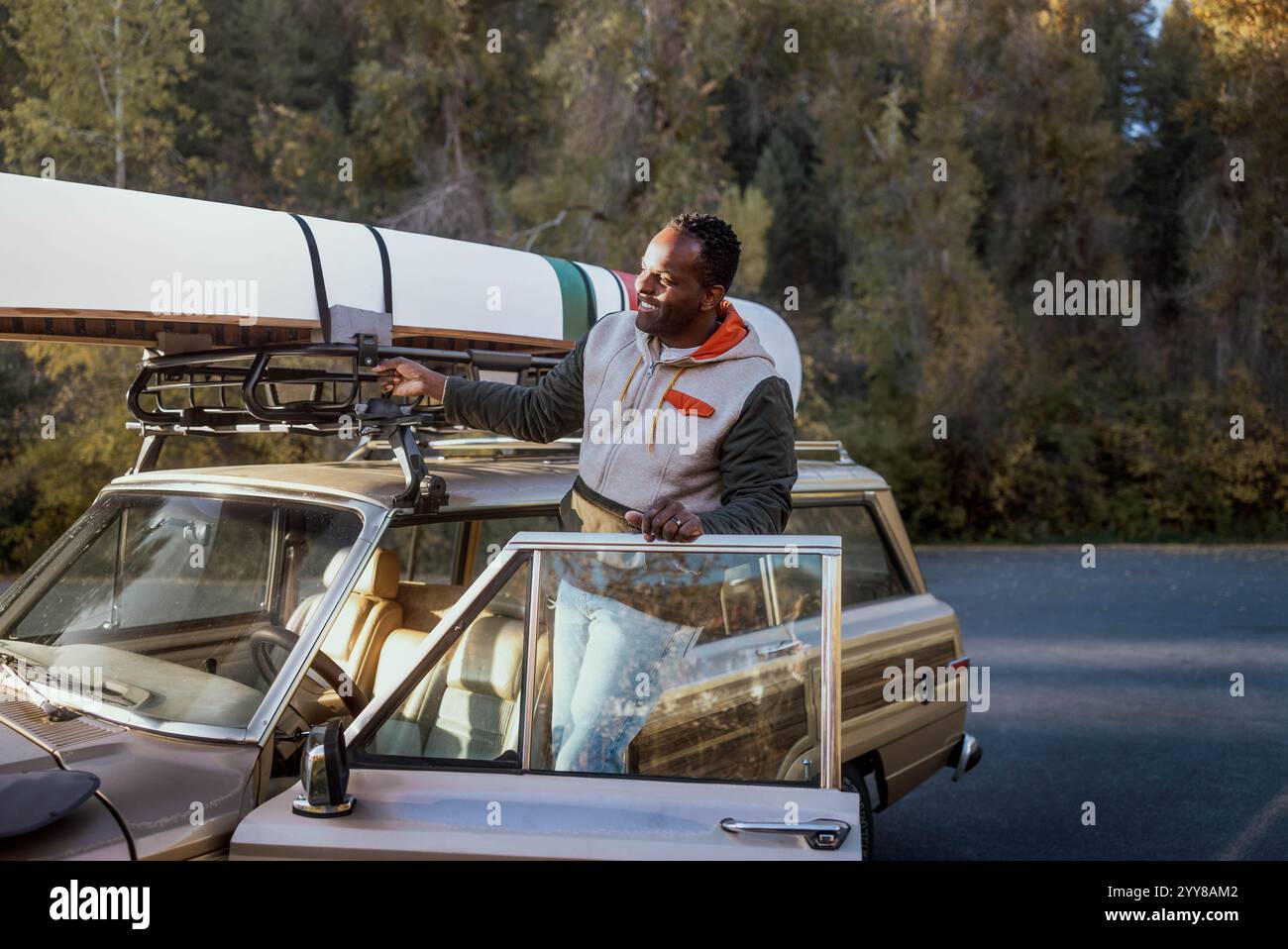 Mann, Der In Den Horizont Blickt, Während Er Mit Kanu Auf Einem Oldtimer Steht Stockfoto