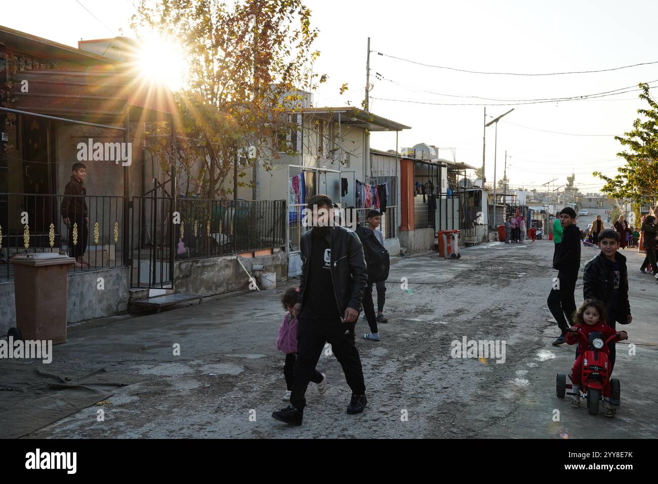 Menschen laufen auf der Straße im Lager Domiz für syrische kurdische Flüchtlinge etwa 18 km südwestlich der Stadt Duhok in der Region Kurdistan. Die Provinz Duhok beherbergt 92.000 syrische Flüchtlinge von 275.000 Flüchtlingen in der Region Kurdistan im Irak, die seit Ausbruch der syrischen Revolution im Jahr 2011 migriert sind. Die meisten von ihnen weigern sich, trotz des Sturzes des Baschar al-Assad-Regimes in ihr Land zurückzukehren, aus Angst vor dem Ausbruch bewaffneter Konflikte zwischen den syrischen Demokratischen Kräften (SDF) und der von der Türkei unterstützten syrischen Nationalarmee oder mit Hayat Tahrir al-Sham und anderen Oppositionskräften, die kooperiert haben Stockfoto