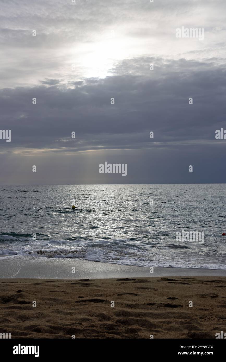 Strand mit Meerblick und bewölktem, bedrohlichem Wetter mit Sonnenstrahlen auf der Insel Kreta in Griechenland im Spätsommer Stockfoto