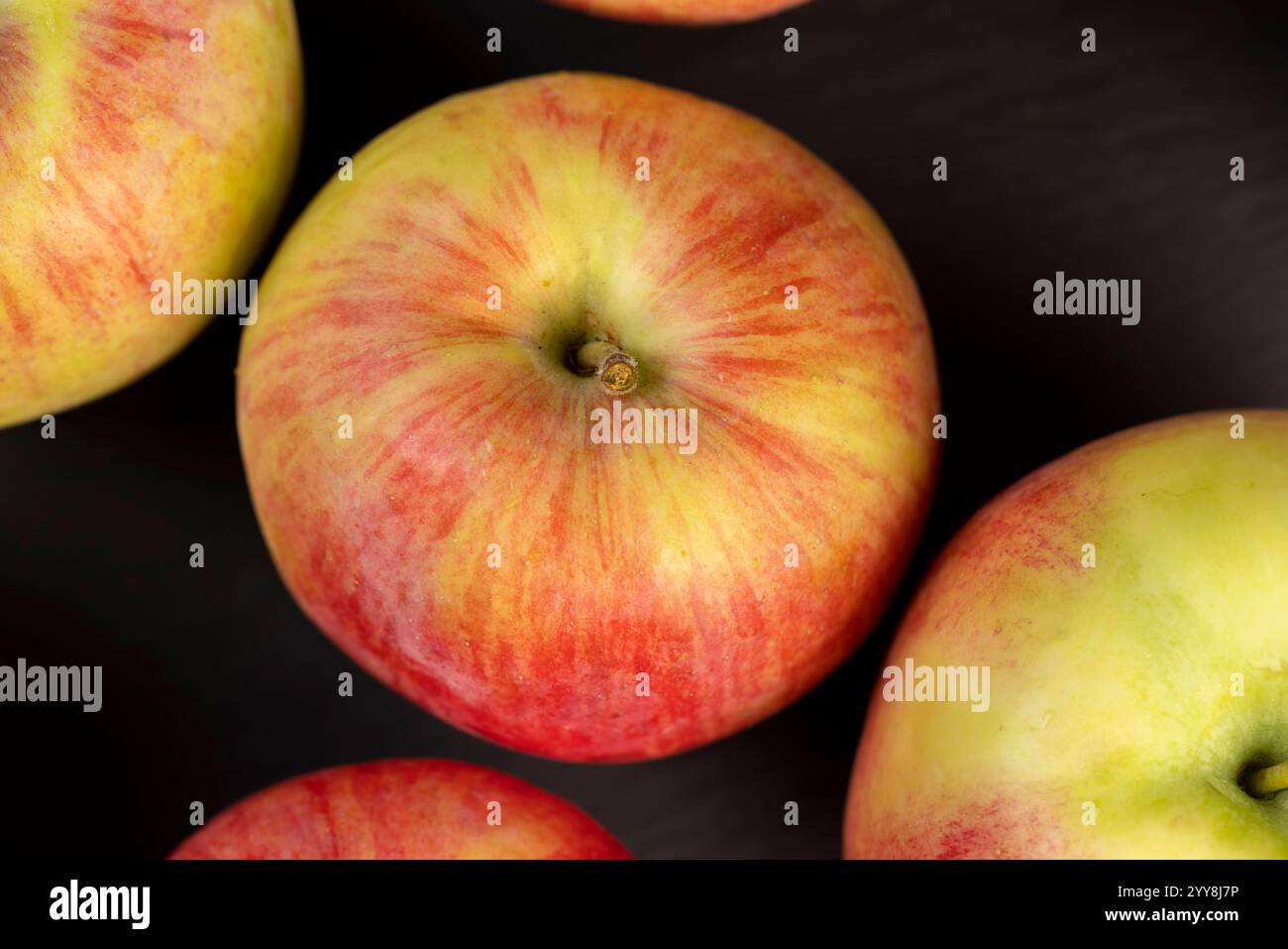 Frischer knuspriger Apfel mit roter und grüner Schale, süßer frisch gepflückter Apfel auf dem Tisch Stockfoto