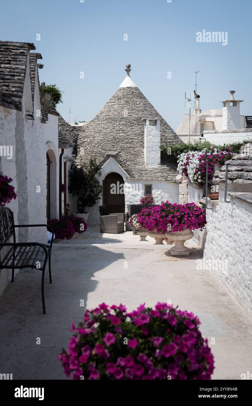 Malerische Trulli-Häuser mit lebendigen Blumen in Alberobello, Italien, das zum UNESCO-Weltkulturerbe gehört Stockfoto