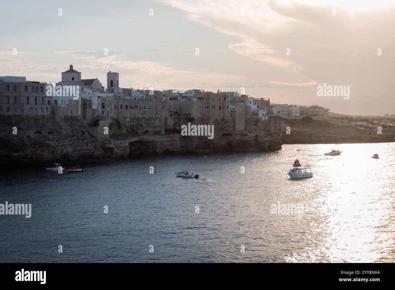 Goldene Stunde entlang der italienischen Küste, wo das Meer auf alte Steinmauern trifft Stockfoto
