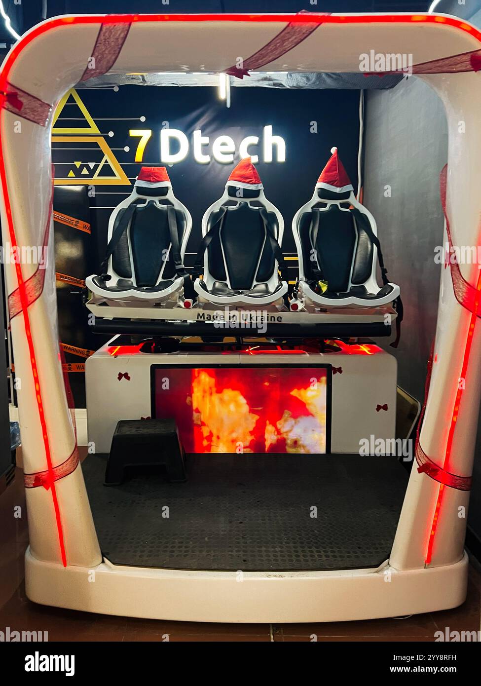 Kiew, Ukraine - 18. Dezember 2024: Virtual-Reality-Gaming-Stühle werden in einem Technikstand mit festlichen Weihnachtsmützen ausgestellt. Bei der Einrichtung wird der Modus betont Stockfoto