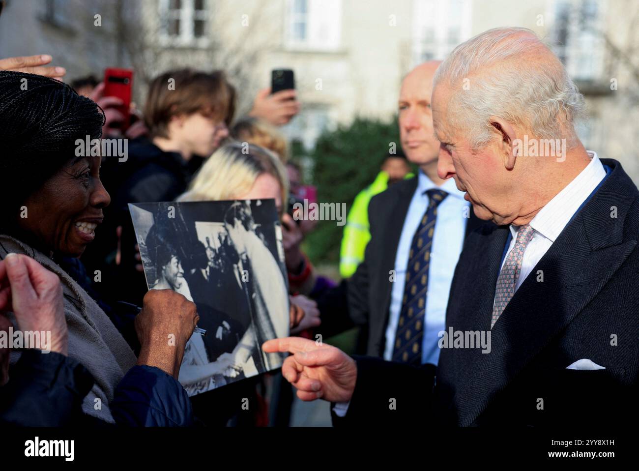 Caroline Akuffo shows Britain's King Charles an old photo of them meeting in Japan in 1970, during a reception at Waltham Forest Town Hall in London, Friday, Dec. 20, 2024. (Mina Kim/Pool Photo via AP) Stockfoto