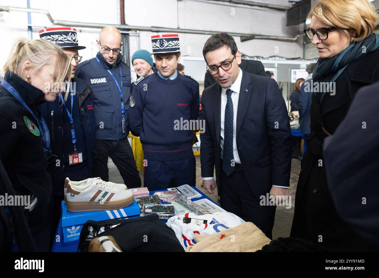 Roissy En France, Frankreich. Dezember 2024. Der europäische Abgeordnete Stephane Sejourne, französischer Generaldirektor für Zoll und Verbrauchsteuern Florian Colas betrachtet beschlagnahmtes Eigentum, während er am 20. Dezember 2024 in Roissy vor der Festzeit um den Flughafen Charles de Gaulle in der Nähe von Paris in Roissy-en-France bei der Kontrolle von Paketen durch Zollbeamte in einer Frachtzone in Roissy vorsieht. Während einer Präsentation der Kontrollen zur Bekämpfung von Fälschungen und einer Stichprobe kürzlich beschlagnahmter Beschlagnahmungen. Foto: Raphael Lafargue/ABACAPRESS. COM Credit: Abaca Press/Alamy Live News Stockfoto