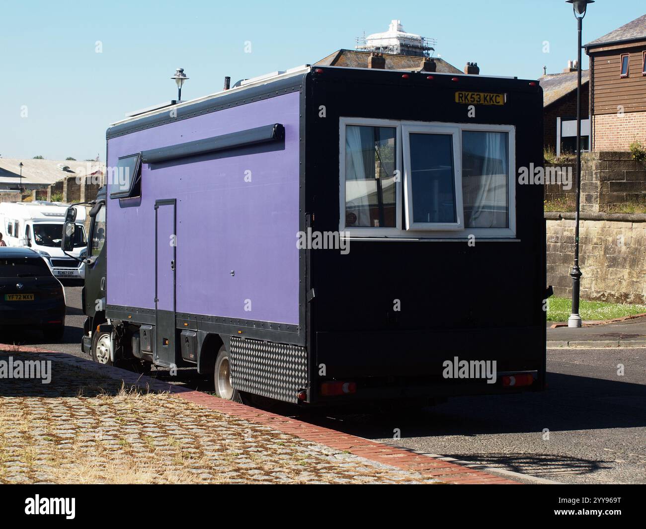 Menschen, die einen alternativen Lebensstil in einem Kastenwagen-Van leben, der in ein Wohnmobilheim am Heck umgewandelt wurde, für ein Paar, das außerhalb des Stromnetzes in Großbritannien lebt. Stockfoto