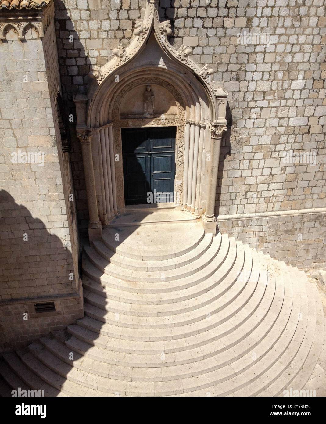Blick auf den kunstvoll dekorierten Eingang der Kirche und die runden Stufen von oben in der Altstadt, Dubrovnik, Kroatien und dem Balkan Stockfoto