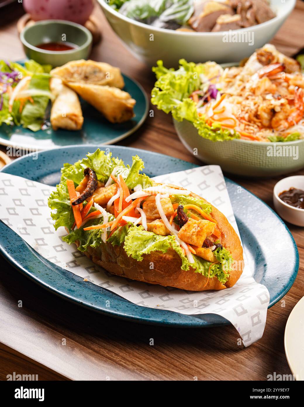 Authentisches vietnamesisches Bánh Mì-Sandwich mit gegrilltem Schweinefleisch, eingelegtem Gemüse, frischem Salat und Koriander, serviert auf einem knusprigen Baguette für einen köstlichen Stockfoto