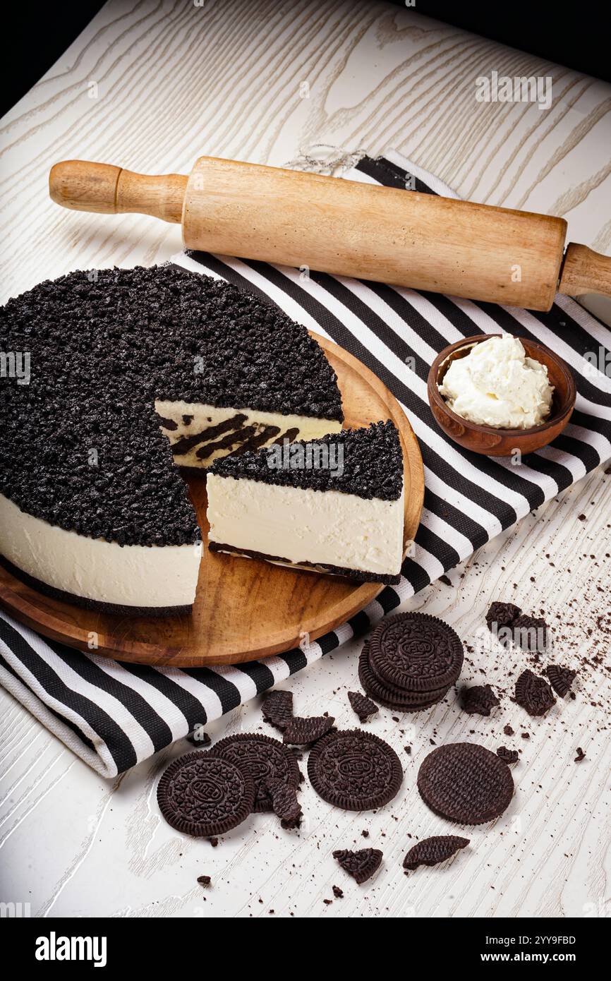 Ein wunderschön gestalteter Schokoladenmousse-Kuchen mit würfelförmigen Schokoladenschwammstücken, begleitet von Schlagsahne und umgeben von dunklem Choco Stockfoto