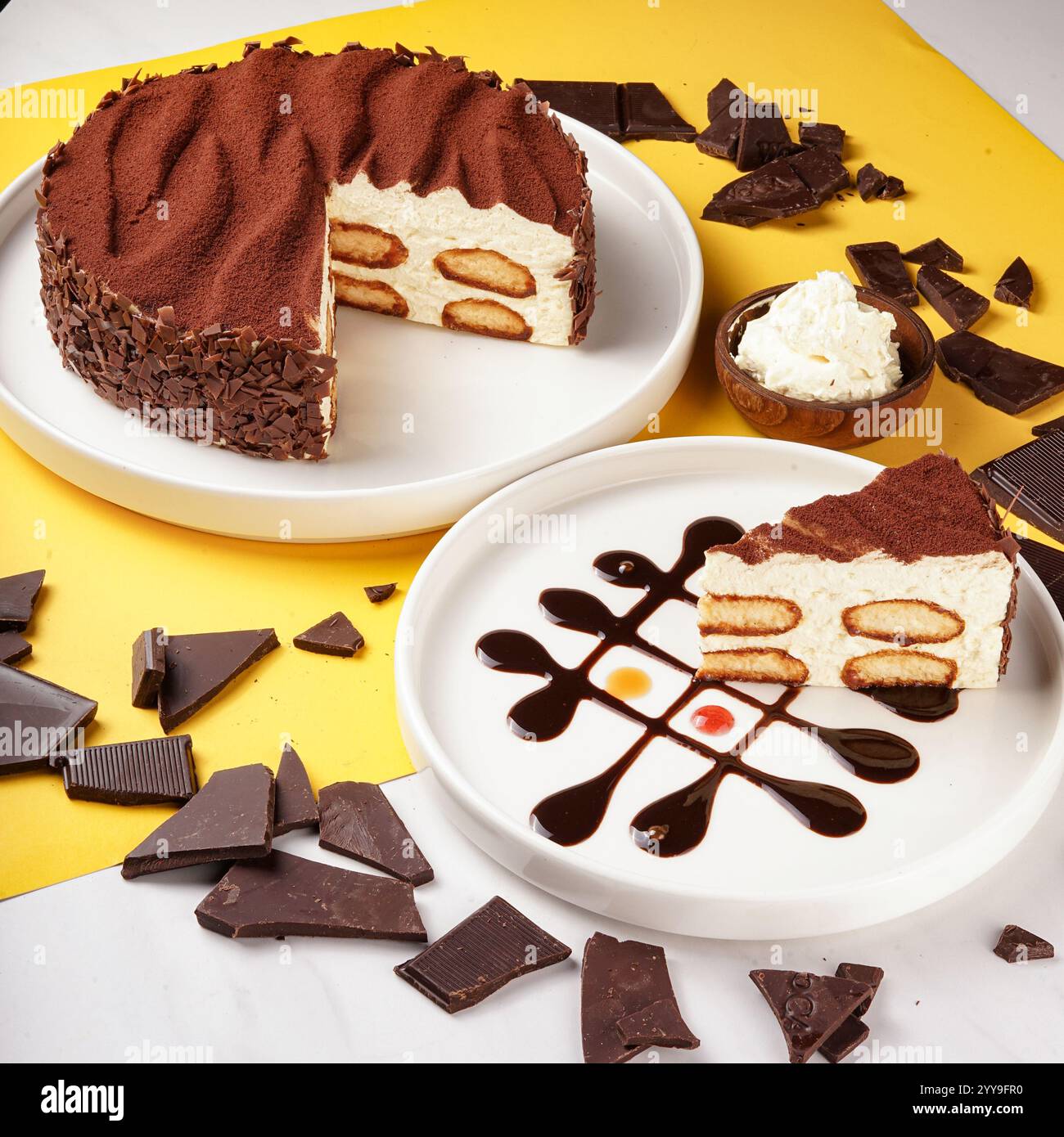 Ein wunderschön überzogenes Stück Schokoladen-Mousse-Kuchen, garniert mit Schokoladenwürfeln, garniert mit frischen Erdbeeren und Schokoladennebel Stockfoto