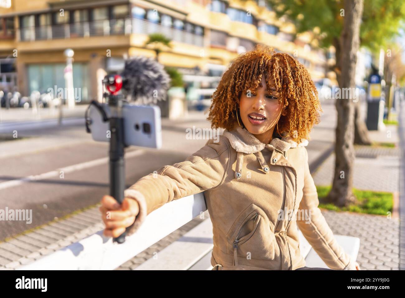 Lateinische Frau und junger Vlogger streamen online und sitzen an einem sonnigen Herbsttag auf einer städtischen Treppe Stockfoto