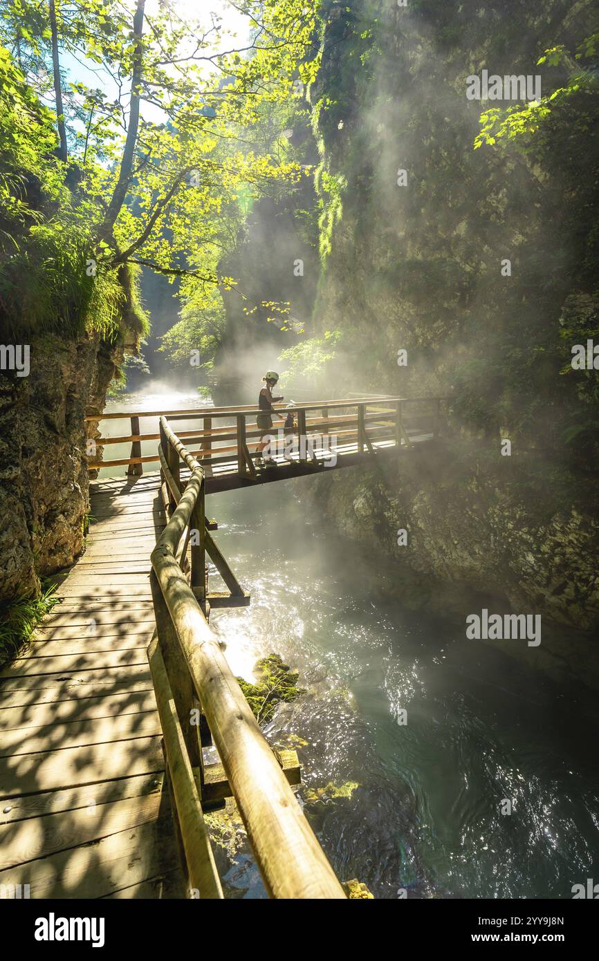 Touristen genießen einen atemberaubenden Blick auf das türkisfarbene Wasser, das durch den engen Canyon in der vintgar-Schlucht in der Nähe von Bled, slowenien fließt Stockfoto