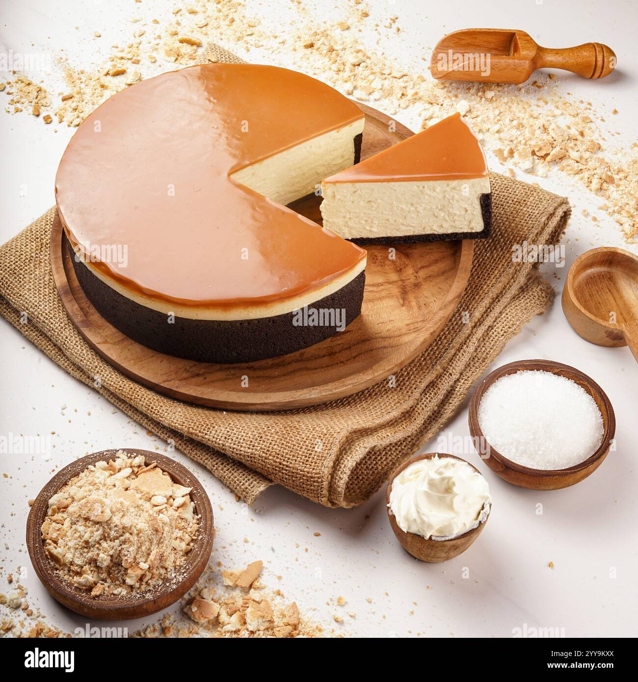 Gemischte Käsekuchen-Scheiben, die im Kreis auf einer weißen Platte angeordnet sind und eine Vielzahl von Aromen und Toppings, einschließlich Schokolade, Obst, Kokos, präsentieren Stockfoto