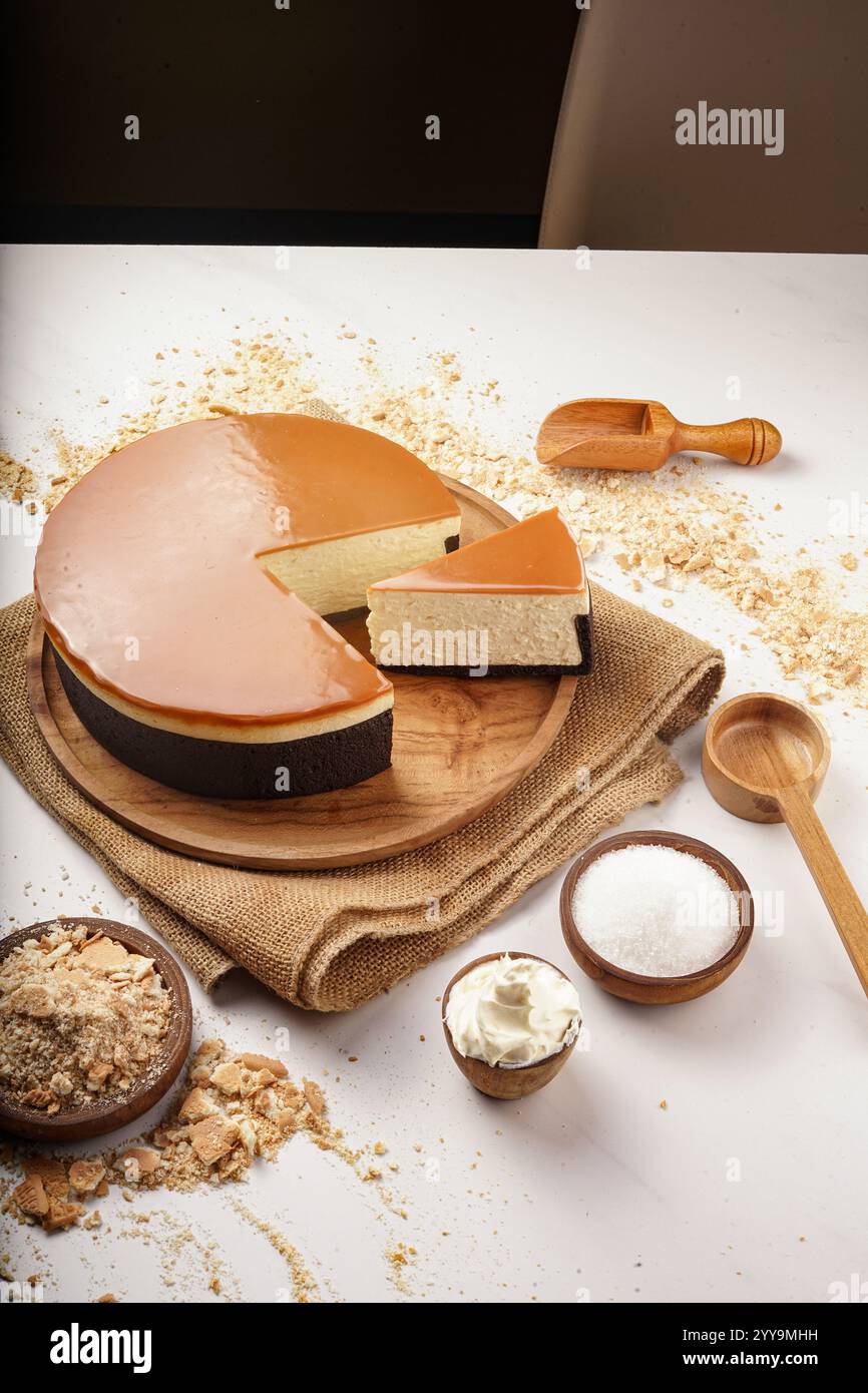 Gemischte Käsekuchen-Scheiben, die im Kreis auf einer weißen Platte angeordnet sind und eine Vielzahl von Aromen und Toppings, einschließlich Schokolade, Obst, Kokos, präsentieren Stockfoto