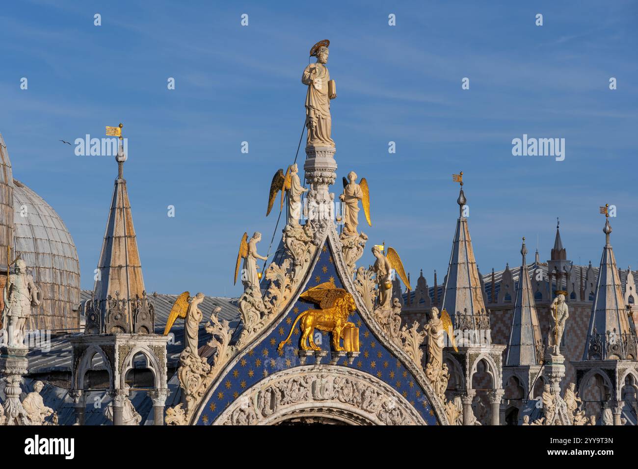 Venedig, Italien - Markusdom oben auf der Westfassade mit Markusstatuen, flankiert von Engeln und geflügeltem Markuslöwen. Stockfoto