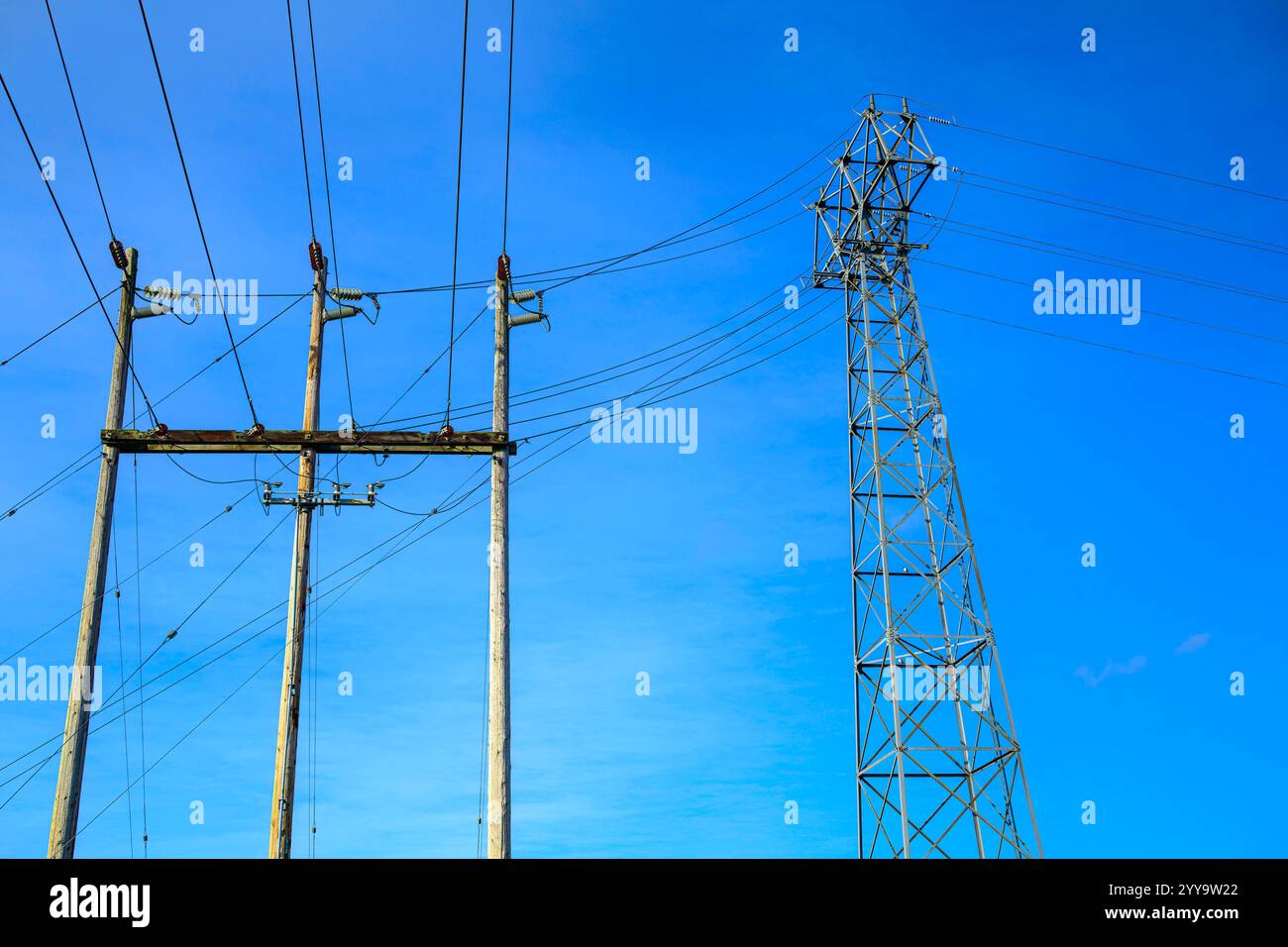 Die elektrischen Übertragungsleitungen verlaufen um zwei Türme Stockfoto