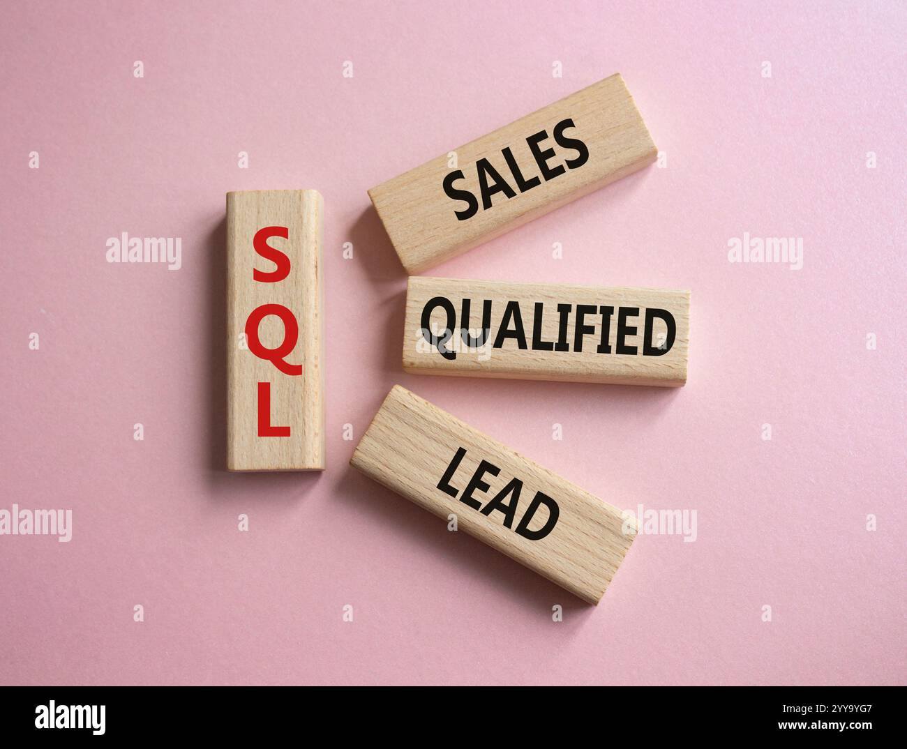 SQL - qualifizierter Lead für Vertrieb. Holzwürfel mit SQL-Wörtern. Schöner rosafarbener Hintergrund. Business- und SQL-Konzept. Kopierbereich. Stockfoto