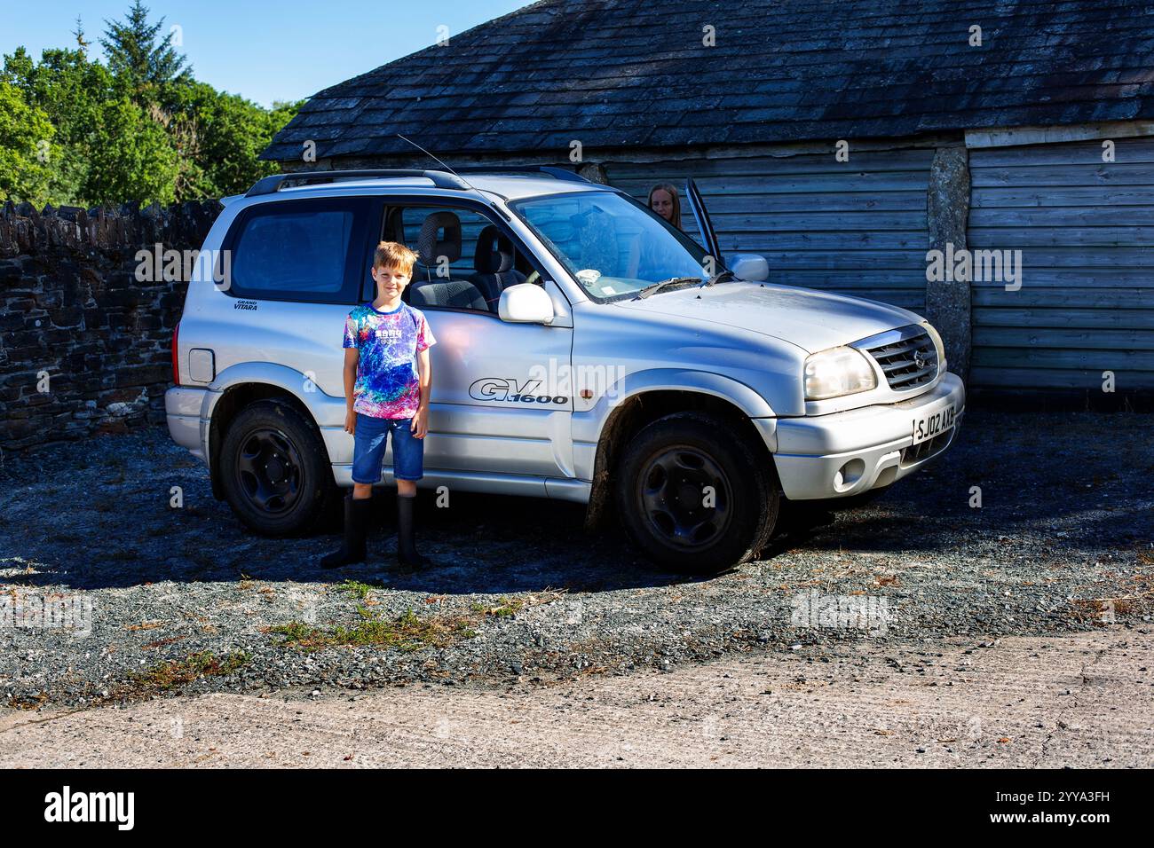 Ein kleiner Junge nach einer Fahrstunde auf einem Feld auf Privatland. Stockfoto