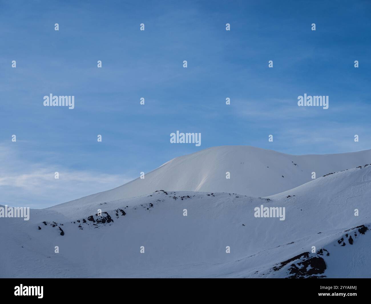 Schneebedeckter Berg in der Nähe von Mont Chaberton, Montgenèvre und Briancoon, Frankreich. Die ruhige Landschaft bietet unberührte Hänge unter einem klaren blauen Himmel. Stockfoto