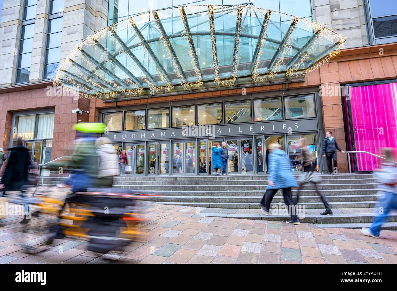 Bewegte sich unscharfe E-Mail vorbei an Käufern am Eingang zum Buchanan Galleries Shopping Centre, Buchanan Street, Glasgow, Schottland, Großbritannien, Europa Stockfoto