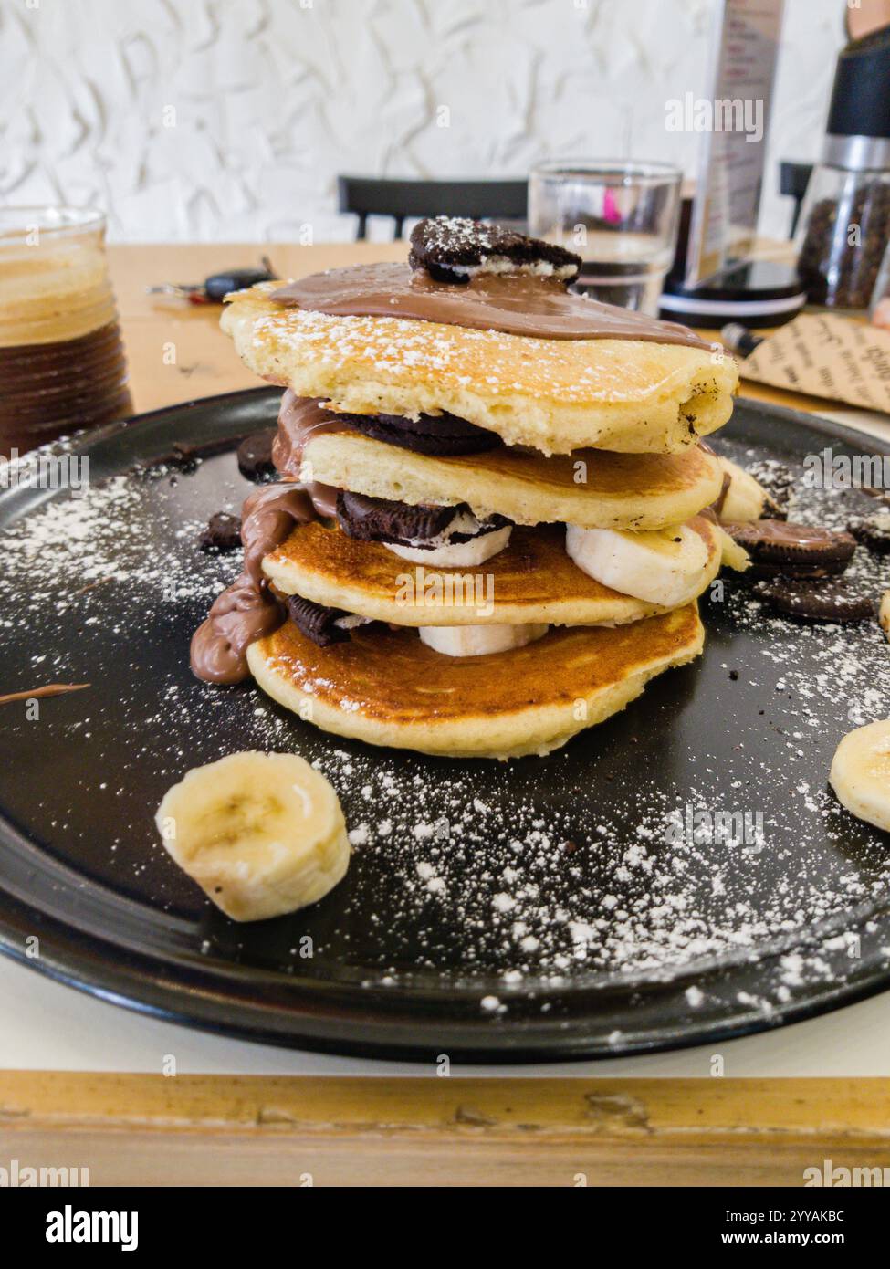 korfu, korfu, Griechenland. 26. September 2020: Stapel von Pfannkuchen mit Schokolade, Banane und Oreo-Keksen. Stockfoto