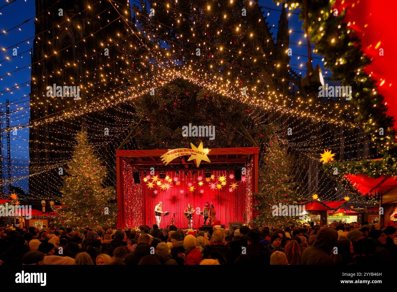 Köln, Deutschland 20. Dezember 2024: Viele Besucher vor der Live-Musikbühne auf dem berühmten weihnachtsmarkt am kölner Dom am Abend Stockfoto