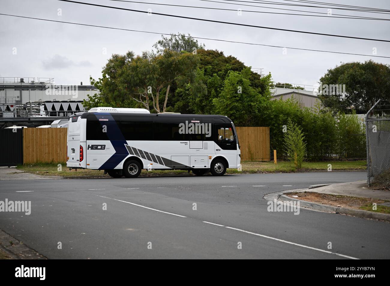 Seitenansicht eines Yutong D7-Busses, der von HG Corporate Buses betrieben wird und an einem bewölkten Tag in einem Industriegebiet im Großraum Melbourne parkt Stockfoto