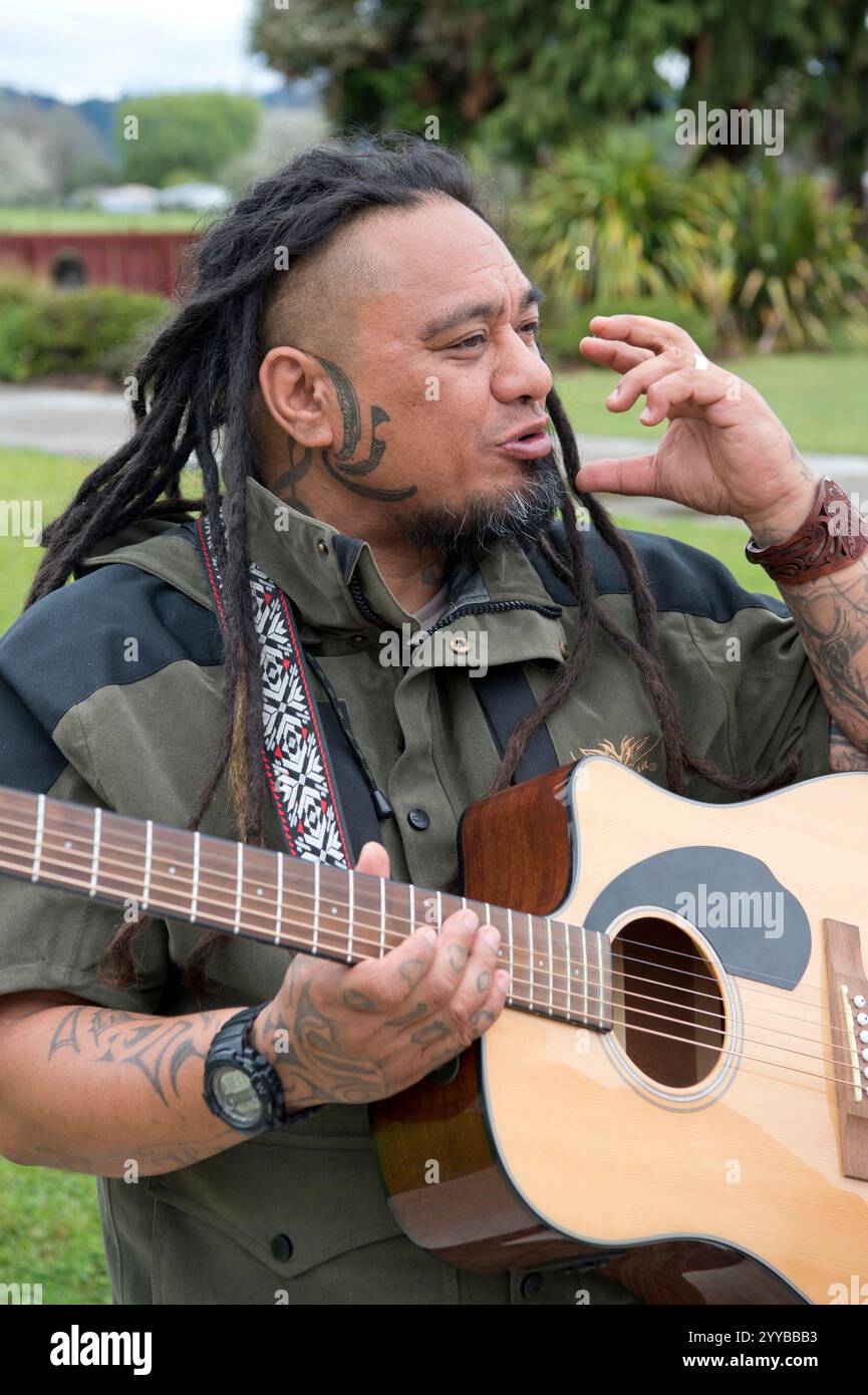 Maori-Mann spielt Gitarre in Neuseeland. Stockfoto