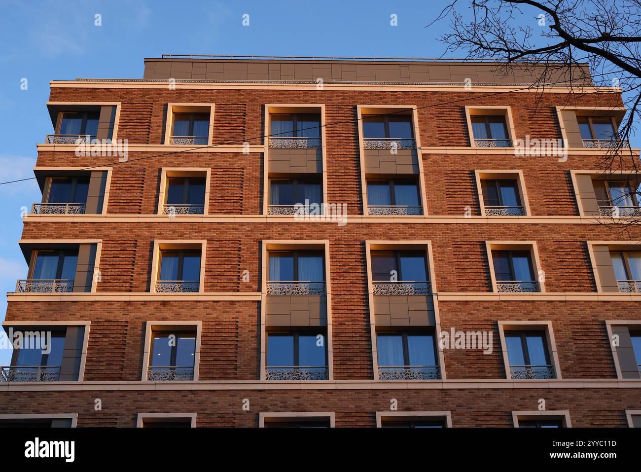 Die moderne Ziegelfassade bietet elegante Balkone und Fenster in zeitgenössischer Architektur Stockfoto