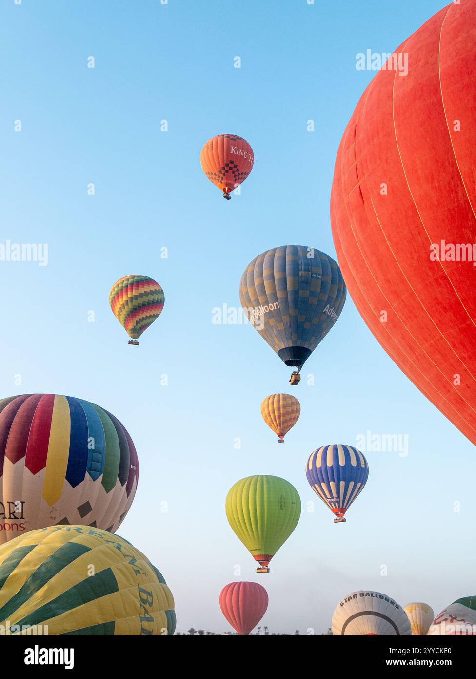 Heißluftballons fliegen über das Tal der Könige in Luxor, Ägypten vor der morgendlichen Kulisse des blauen Himmels Stockfoto